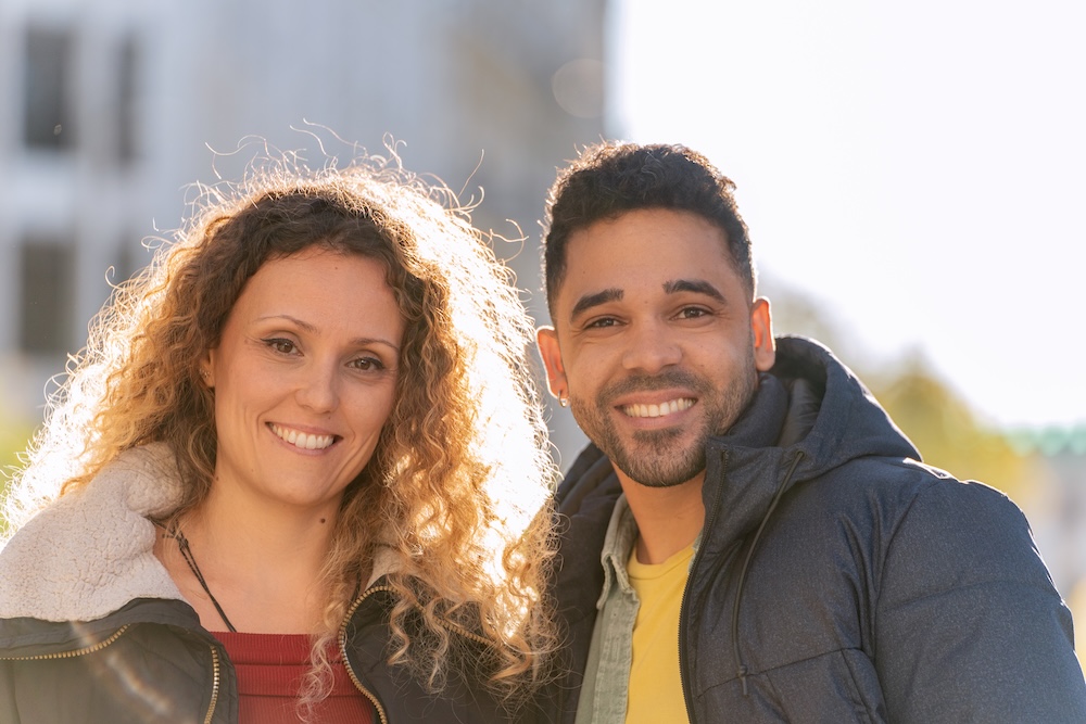 Happy multi ethnic couple smiling outdoors in urban setting